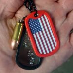 9mm Bullet Pendant next to dogtag with red silencer and USA flag sticker