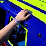 Finger reading Braille Nameplate on Race Car