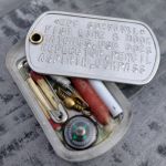 Dogtag Pillbox Micro-Survival Kit with survival gear contents embossed on dogtag, after carrying in pocket for 1 year