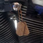 Rusty Steel Dog Tag as keychain on vintage Harley motorcycle closeup